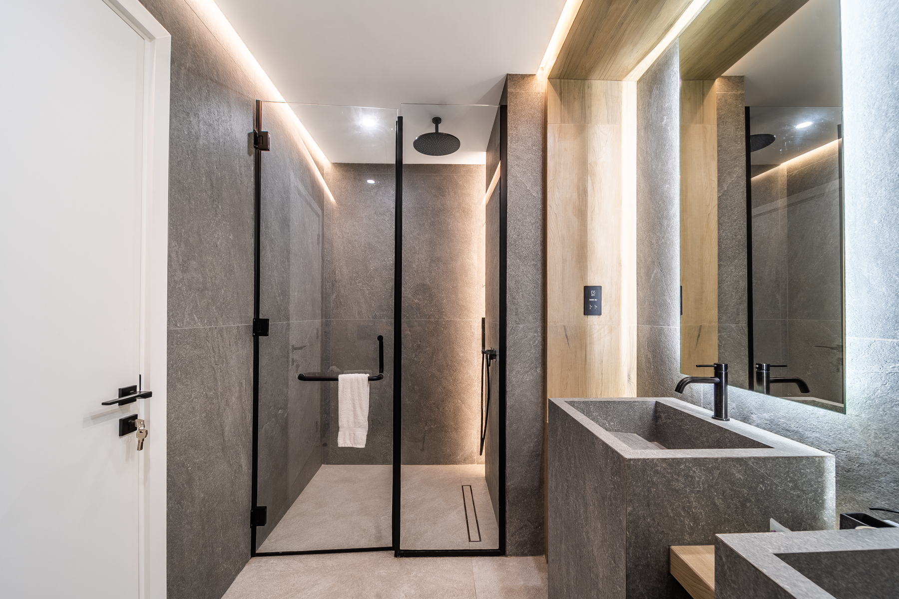 Stone-clad walk-in shower room at Emaar Beachfront