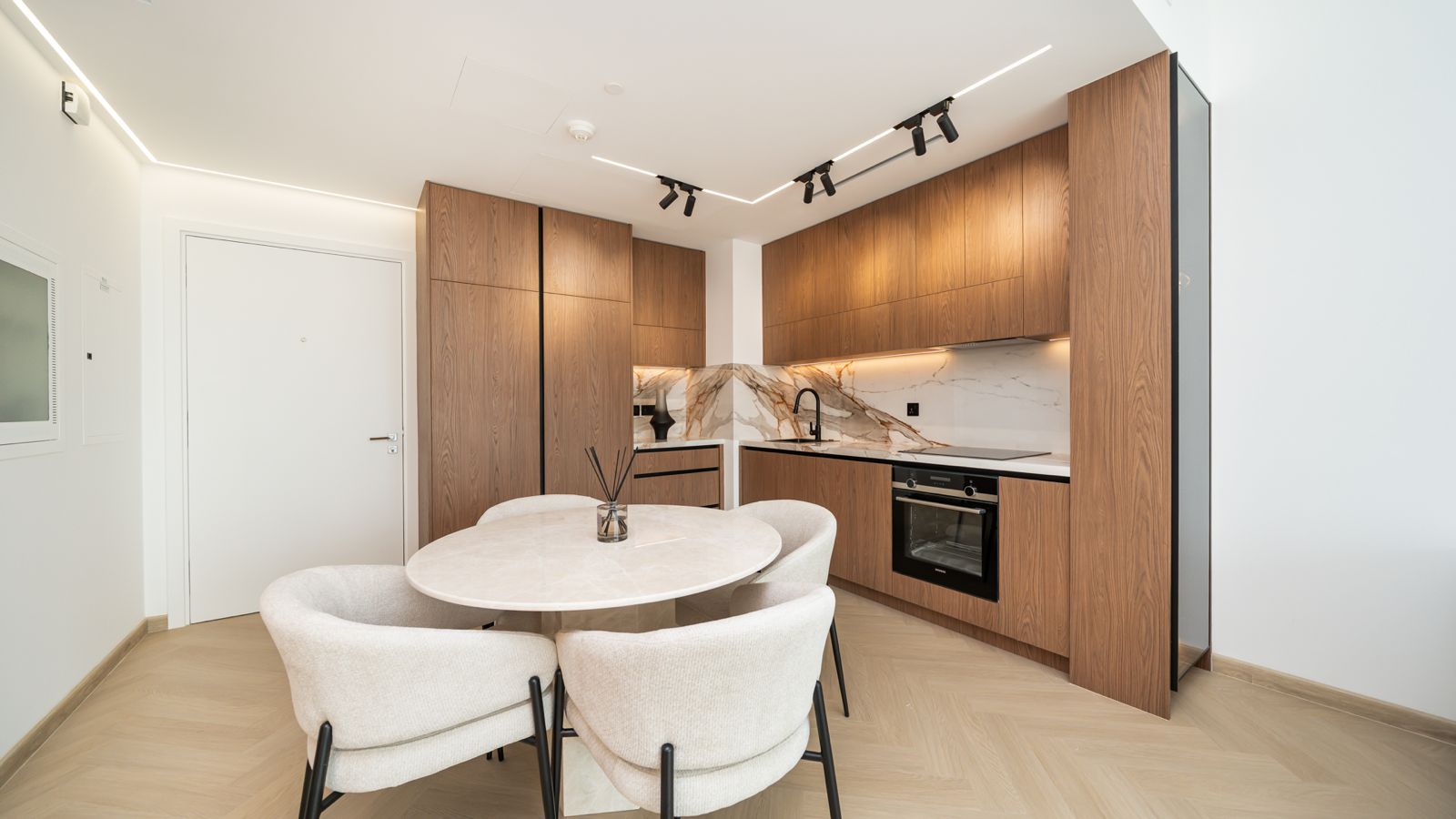 Kitchen with walnut joinery and marble backsplash at Emaar Beachfront