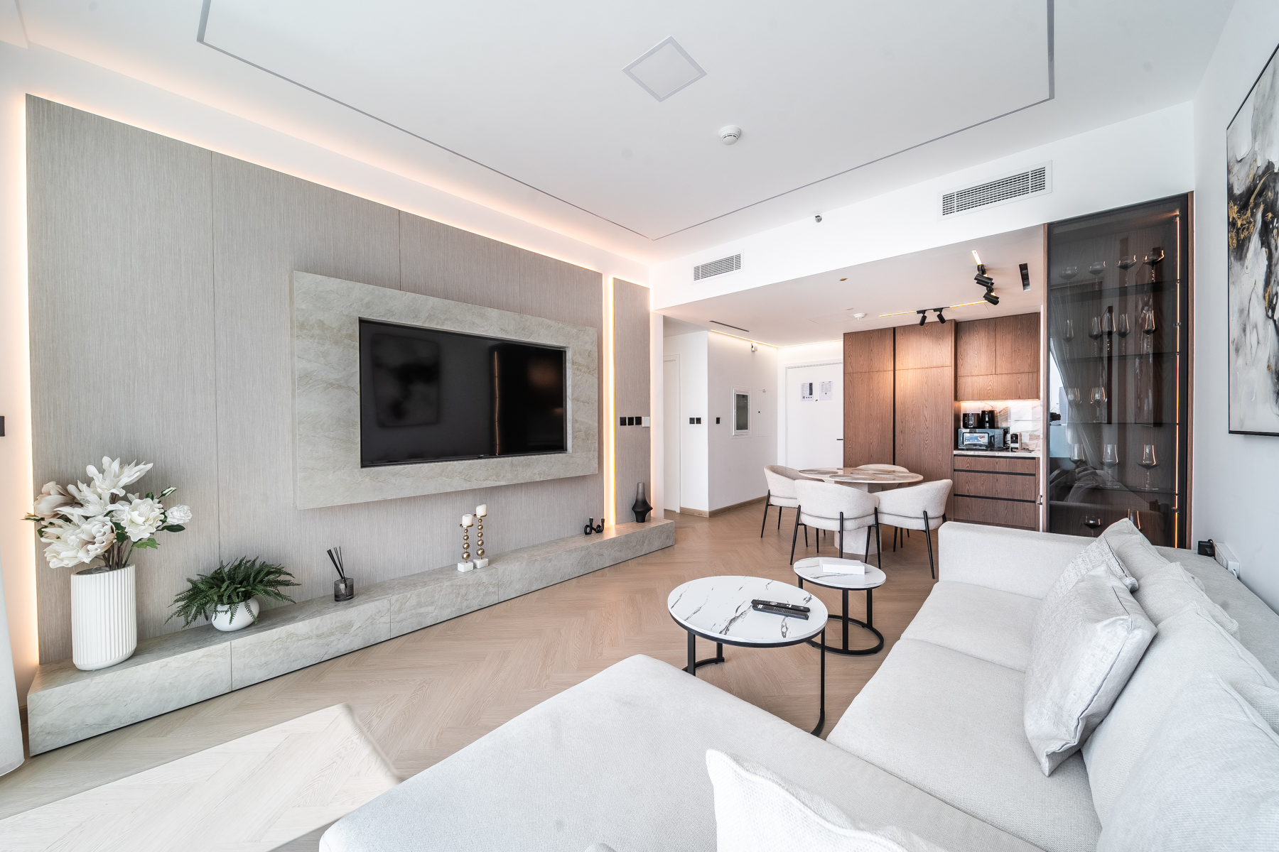 Living room with lit stone media wall at Emaar Beachfront